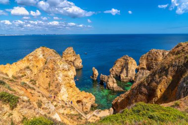 Açık turkuaz mavi deniz Ponta da Piedade kıyısı Lagos Portekiz kıyılarına doğru yürüyor