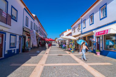 14 Mayıs 2024 Salı günü Portekiz 'in Porto Covo, Sines, Batı Alentejo sahil şeridinde dükkanları, kafeleri ve işletmeleri olan cadde