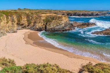 Dalgalı açık mavi deniz ve kumlu sahil Porto Covo Portekiz 'i temsil ediyor.