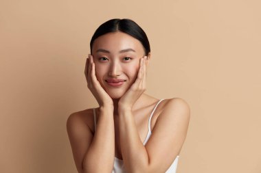 Gülümseyen Kadın Hatunlara Dokunuyor. Cildine Dokunan ve Gülümseyen Çekici Kadın Portresi. Kadın Görünümü ve Cilt Bakımı 