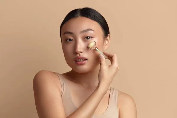 Masaż Twarzy Azjatka Wykorzystująca Jade Facial Roller Pielęgnacji Skóry Zabiegi — Zdjęcie stockowe