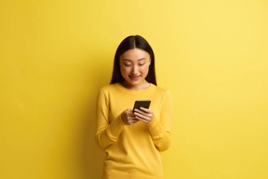 Happy Woman Smartphone tecrit edildi. Asyalı Kız Mesajlaşması, Sosyal Ağ 'da Sohbet, Cep Telefonu Uygulaması Kullanımı, Arkadaşlarla İnternette Mesajlaşma, Haberleri Paylaşma, Sarıda İzole Etme 