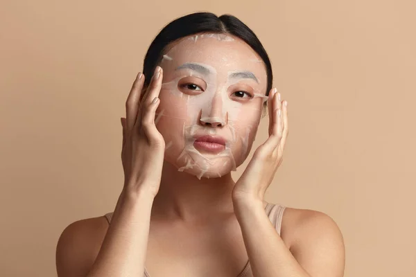 Beauty Woman Face Mask. Portrait Of Beautiful Girl Posing in Sheet Mask at Healthy Fresh Skin. Closeup Of Attractive Woman With Natural Makeup And Mask On Facial Skin. High Resolution