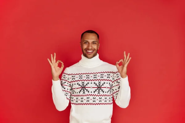 stock image Smiling Man Showing Ok Gesture. Satisfied Multiracial Guy Making Ok Symbol with Fingers, Approving, Satisfied. Indoor Studio Shot Isolated on Red Background 