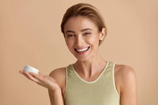 白种人女人用奶油 手握新鲜护肤乳液瓶的女模套装 快乐女孩在眼皮底下使用化妆品的肖像 恐怖概念 高分辨度 — 图库照片