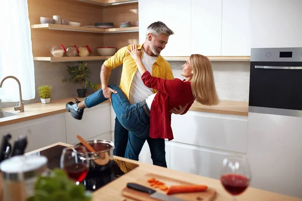 Romantic Couple Dancing Kitchen. Playful Mature Spouses in Casual Clothing Dancing And Smiling In The Kitchen At Home. Romantic Date Concept