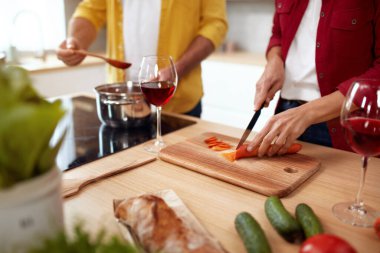 Mutfaktaki çift. Son sınıf aile yemekleri evde birlikte. Salata için taze organik sebzeleri kesen kadının yakın görüntüsü. Romantik Hafta Sonu Konseptinde Sağlıklı Diyet 