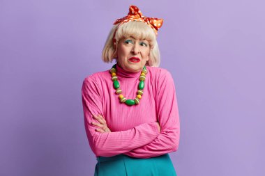 Tatmin Olmayan Büyükanne Posing Stüdyosu. Kıdemli Kadın İnançsızlığını İfade Ediyor, Sıkılmış, Hayal kırıklığına uğramış, Violet Stüdyo Stüdyosu 'nun arka planında izole edilmiş kötü haberler 