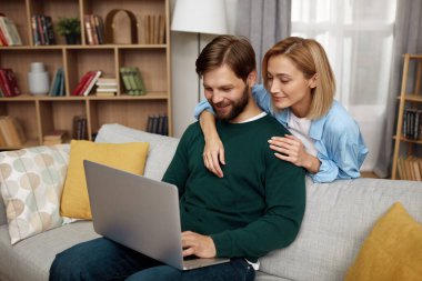 Birlikte dizüstü bilgisayar kullanan çift. Karı koca bilgisayar ağını paylaşıyor, gülüyor ve komik içerik arıyor. Teknoloji ve İnsanlar Konsepti 