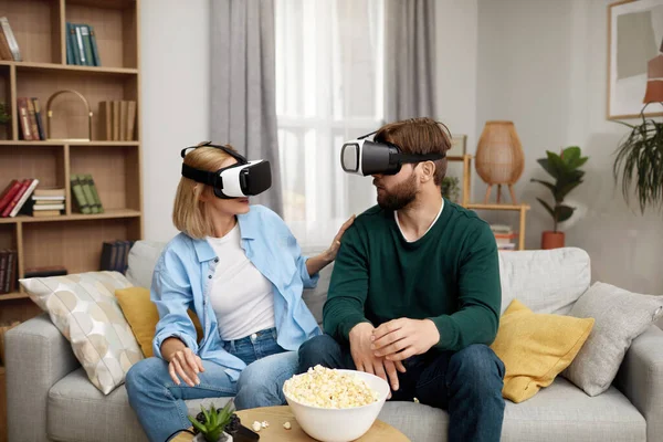 Happy Couple Playing VR Games. Boyfriend And Girlfriend Enjoying Virtual Reality In Their Apartment. Cheerful People Having Fun With New Trends Technology. Gaming concept