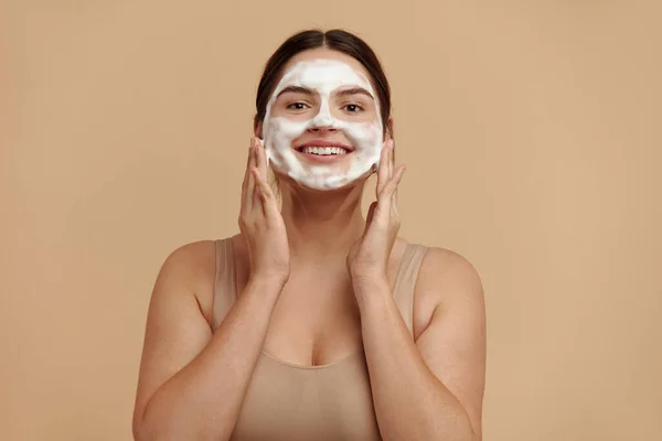 Cleaning Face. Smiling Full Figured Woman Cleaning Facial Skin with Foam Soap. Happy Girl Cleansing Face Applying Facial Cleanser Closeup. High Resolution