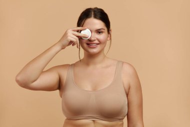 Beyaz yastıklı kadın temizleme yüzü. Makyaj beyazı pamuk pedi çıkartan güzel kız. Kozmetik pedi ile yüz derisinden çıkarılan mutlu kadın. Yükseklik Kalitesi Resmi 