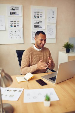 Smiling Businessman Calling Laptop. Successful Young Man Explaining To Laptop Screen While Working At Office 