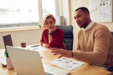 Serious Businesspeople Working Computer At Office. Focused Colleagues Couple Discussing Laptop Screen In Modern Office. Teamwork Concept
