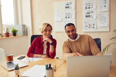 Cheerful Businesspeople Working Computer At Office. Happy Colleagues Couple Discussing Laptop Screen In Modern Office. Teamwork Concept