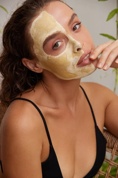 Face Mask Woman. Young Relaxed Woman Enjoying Skin Care Routine at Street. Attractive Woman With Makeup And Clay Mask On Her Skin. Spa Procedure Concept