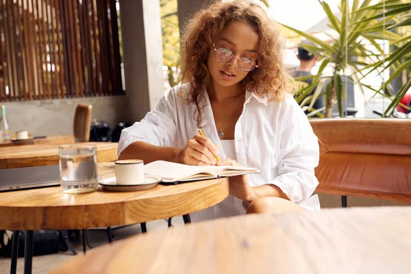 Freelancer Cafe Serious Woman Glasses Writing Something Notebook Remote Job — ストック写真