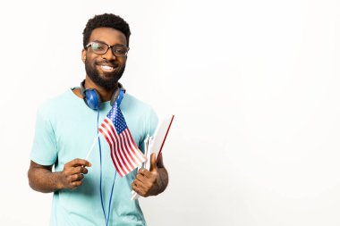 Boynunda kulaklıkları olan neşeli Afro-Amerikan bir adam, beyaz bir arka plana karşı rahat, vatansever ve mutlu bir yaşam tarzını tasvir ediyor..