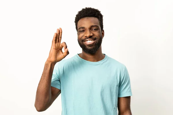 开朗的年轻非洲男性微笑着 摆出一副不错的手势 在明亮的背景下表示认可和积极向上 — 图库照片