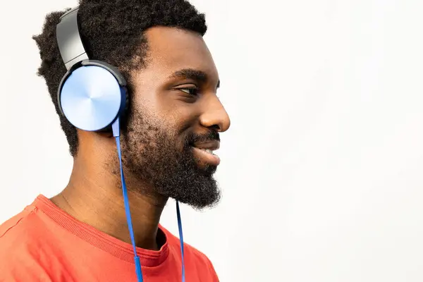 Boczny Profil Radosnego Afroamerykanina Niebieskich Słuchawkach Czerwonej Koszuli Odizolowanego Białym — Zdjęcie stockowe