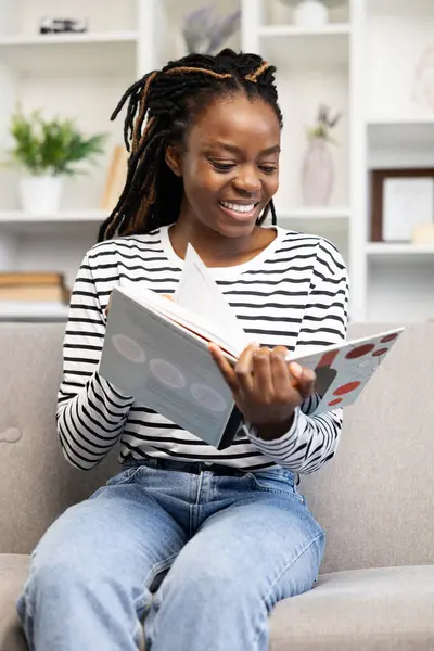 Χαρούμενη Αφρο Αμερικανίδα Που Χαλαρώνει Στο Σπίτι Κάθεται Έναν Καναπέ Εικόνα Αρχείου