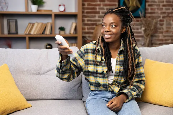 Konten Afrika Amerika Wanita Santai Sofa Memanfaatkan Remote Control Untuk — Stok Foto