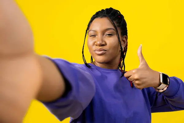 女人以大拇指向上的姿势自拍 以明亮的黄色背景展现积极和肯定的一面 — 图库照片