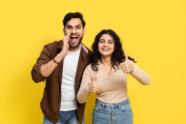 Genç bir adam, mutlu bir kadının yanında, sarı bir arka plana karşı duran ve heyecan ve onay veren bir mesaj veriyor..