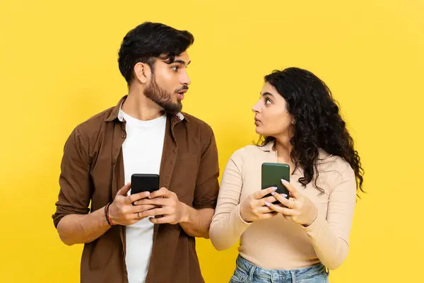 Pasangan Penasaran Melihat Satu Sama Lain Sambil Memegang Smartphone Terhadap — Stok Foto