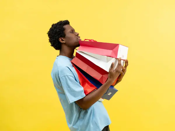 Young Man Overwhelmed Shopping Bags Yellow Background Concepts Include Retail — Stock Photo, Image