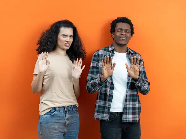 Young Multiethnic Couple Showing Stop Gesture Orange Background Rejection Denial — Stock Photo, Image