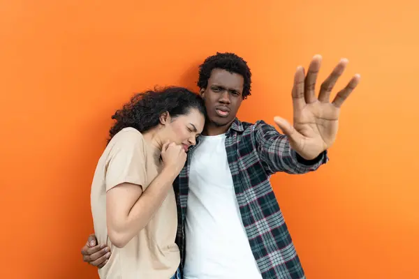 PROTECTION AND SUPPORT - Man Comforting Woman Against Orange Background