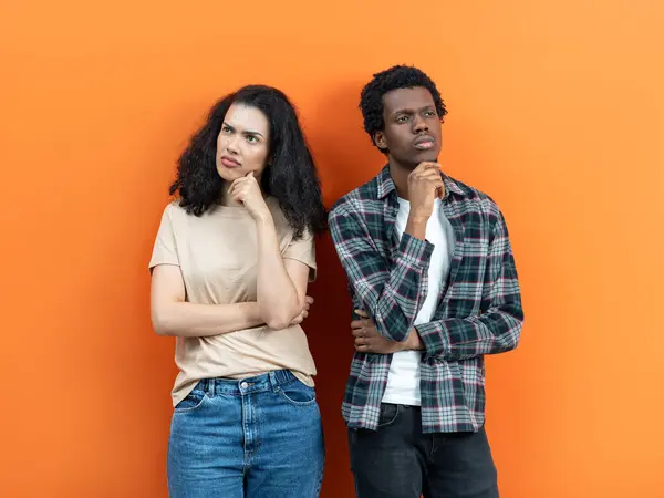 Nachdenkliches Paar Mit Offensivem Ausdruck Das Vor Orangefarbenem Hintergrund Steht — Stockfoto