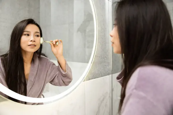 Mujer Joven Usando Rodillo Jade Cara Baño Lujo Reflejando Momentos — Foto de Stock