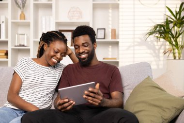 Oturma odasında tabletle güzel vakit geçiren çift.