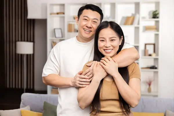 Glückliches Asiatisches Paar Genießt Zweisamkeit Wohnzimmer Bild Eines Fröhlichen Paares lizenzfreie Stockfotos