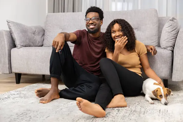 stock image Happy Couple At Home With Dog. Smiling Man And Woman Sitting On Floor Indoors, Pet Companion