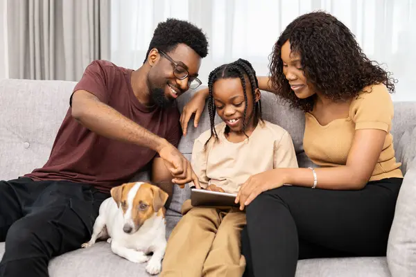 Mutlu Afro Amerikan Ailesi Köpek Kanepede Tablet Zamanının Keyfini Çıkarıyor Stok Fotoğraf