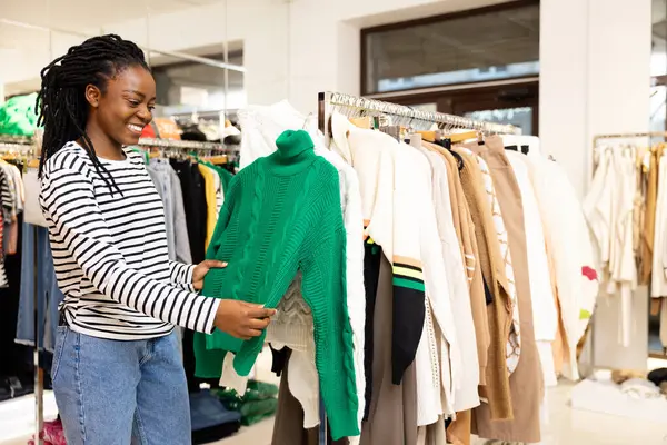 Счастливая Молодая Женщина Делающая Покупки Модном Магазине Выбирает Зеленый Свитер Лицензионные Стоковые Фото