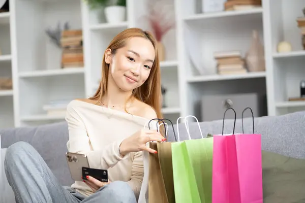 Happy Young Woman Shopping Bags Credit Card Shopping Online Home lizenzfreie Stockfotos