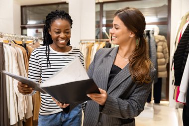 Moda Butiği 'nde Afro Kadın ve Alışveriş Danışmanı, Mutlu Müşteri Joy' la Tasarımları Tartışıyor, Modern Moda Mağazası Etkileşimi, Müşteri Danışmanı.