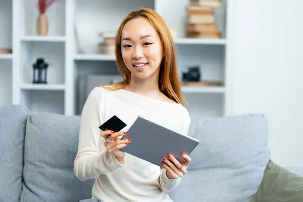 Happy Young Woman Using Tablet Holding Credit Card Couch Online Stockbild