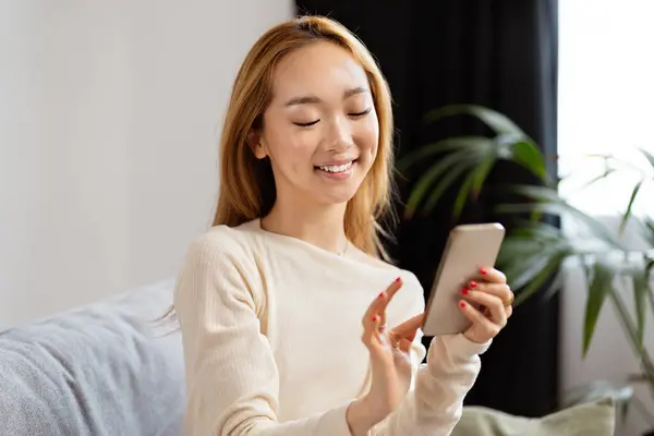 Young Asian Woman Smiling Using Smartphone Home Happy Modern Lifestyle รูปภาพสต็อก