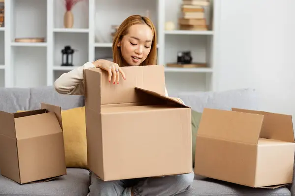 Young Woman Unpacking Boxes New Home Exuding Happiness New Beginnings ภาพถ่ายสต็อกที่ปลอดค่าลิขสิทธิ์