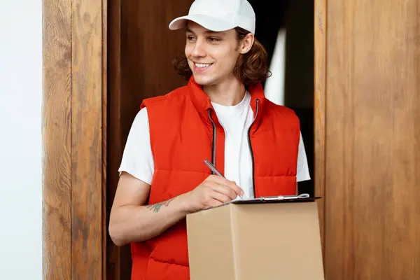 Friendly Delivery Man Package Standing Door Smiling Service Worker Red Stockbild
