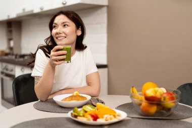 Modern Mutfakta Sağlıklı Kahvaltı Yapan Genç Kadın. Olumlu, yeni bir başlangıç ve sağlıklı beslenme ile günlük yaşam tarzı. Gülümseyen, Rahatlamış, Sağlıklı, Sabah Rutini.
