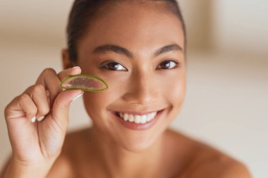 Cilt Güzeli. Aloe Vera 'yı tutarken gülümseyen kadın gözlerinin yanında cildini ve doğal güzelliğini aydınlatıyor.