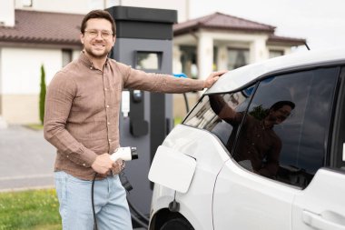 Evde Elektrikli Araç Yükleyen Adam