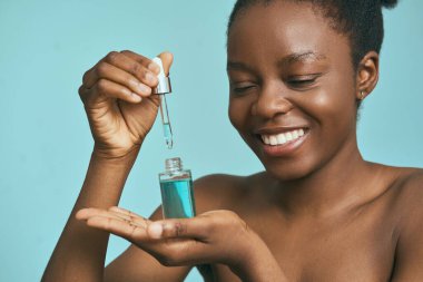 Kadın yüz serumunu damla ile uyguluyor. Cilt bakım rutini konsepti. Taze ve Parlak Deri.