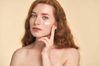 Yüz kremi süren kadın.